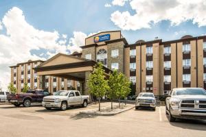 a hotel with trucks parked in a parking lot at Comfort Inn & Suites in Fort Saskatchewan