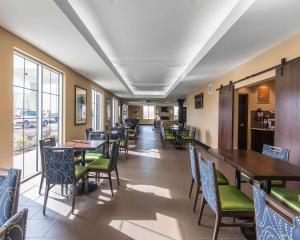 a dining room with tables and chairs and windows at Comfort Inn & Suites Airport North in Calgary