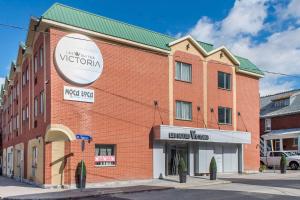 un bâtiment en briques avec un panneau sur son côté dans l'établissement Les Suites Victoria, Ascend Hotel Collection, à Gatineau