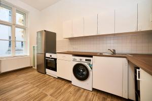 uma cozinha com uma máquina de lavar roupa e um lavatório em Bearlin City Apartments - City Center East em Berlim