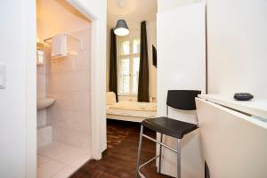 a bathroom with a sink and a stool in a room at Bearlin City Apartments - City Center East in Berlin