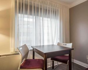 a dining room table with two chairs and a window at The Saint James Hotel, Ascend Hotel Collection in Toronto