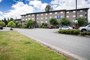 a large building with cars parked in a parking lot at Comfort Inn & Suites Langley in Langley