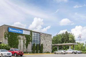 a building with cars parked in a parking lot at Travelodge by Wyndham Trois-Rivieres in Trois-Rivières