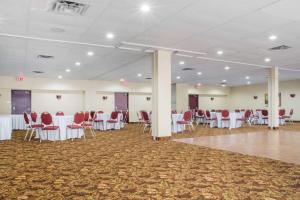 a banquet hall with white tables and red chairs at Quality Inn in Bracebridge +37 photos