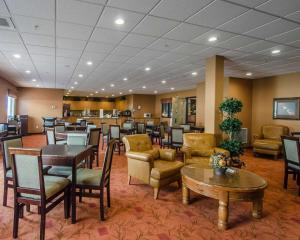 Quality Inn & Suites في غراندي بريري: غرفة انتظار في مستشفى مع طاولات وكراسي