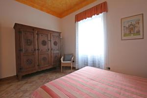 1 dormitorio con 1 cama, vestidor y ventana en Mella Bellagio Rosa Dei Venti - Elegante appartamento nel cuore di Bellagio con parcheggio privato, en Bellagio