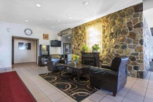 a lobby with a stone wall and a table and chairs at Econo Lodge Sudbury in Sudbury