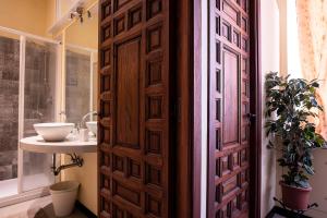 a bathroom with a wooden door and a sink at Casa Costa Classica in Genova +21 photos