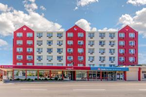 a large red and white building with a store at Clarion Hotel Sudbury in Sudbury