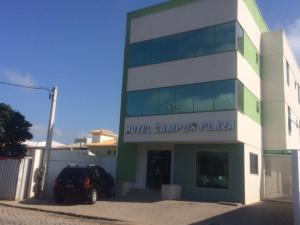 a building with a car parked in front of it at Hotel Campos Plaza in Campos dos Goytacazes