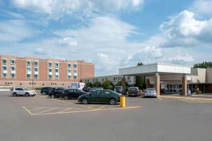 un parking avec des voitures garées devant un bâtiment dans l'établissement Clarion Hotel & Suites, à Brandon