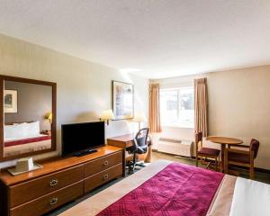 a hotel room with a bedroom with a bed and a television at West End Lodge in Pagosa Springs