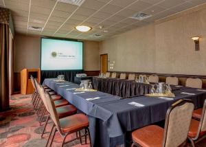 a conference room with a long table with chairs and a screen at The Golden Hotel, Ascend Hotel Collection in Golden