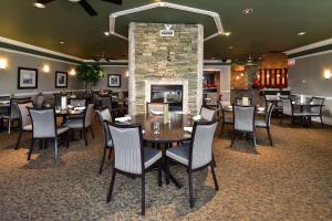 a restaurant with tables and chairs and a fireplace at Clarion Hotel & Conference Centre in Pembroke