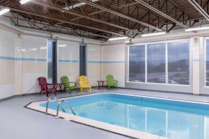 uma piscina com cadeiras e cadeiras coloridas num edifício em Quality Hotel & Suites em Gander