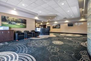 une salle d'attente avec des chaises et une télévision à écran plat dans l'établissement Clarion Hotel & Suites, à Brandon