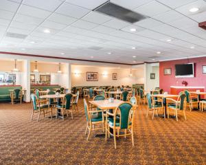 a dining room with tables and chairs and a flat screen tv at Clarion Inn and Events Center Pueblo North in Pueblo