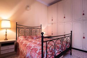 ジェノヴァにあるCasa Costa Classicaのベッドルーム(ベッド1台、ランプ、キャビネット付)
