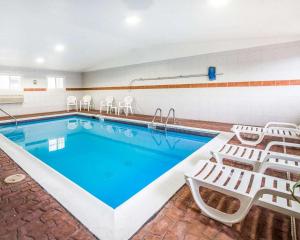 a swimming pool with chairs and a pool at Econo Lodge in Canon City