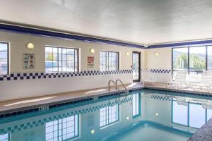 a swimming pool in a hotel with chairs and windows at Quality Inn & Suites Vail Valley in Eagle