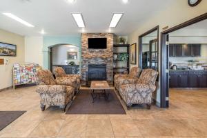 a living room with chairs and a fireplace at Baymont by Wyndham Loveland - Fort Collins Area in Loveland