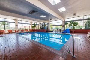 a large swimming pool with blue water and windows at Quality Inn South Colorado Springs in Colorado Springs