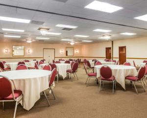 a conference room with white tables and red chairs at Clarion Inn and Events Center Pueblo North in Pueblo