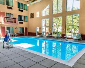 a pool at a hotel with chairs and tables at Quality Inn and Conference Center Greeley Downtown in Greeley