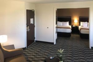 Quality Inn & Suites Denver International Airport في دنفر: غرفة فندقية بسريرين واريكة