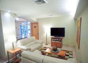 a living room filled with furniture and a tv at Sleep Inn Hotel Paseo Las Damas in San José