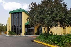 a yellow building with a tree in front of it at Clarion Inn in Fort Collins