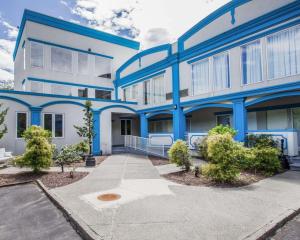 un edificio blu e bianco con alberi di fronte di Econo Lodge Inn & Suites Old Saybrook - Westbrook a Old Saybrook
