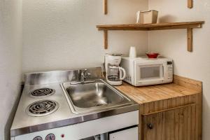 a small kitchen with a sink and a microwave at Rodeway Inn Rifle in Rifle
