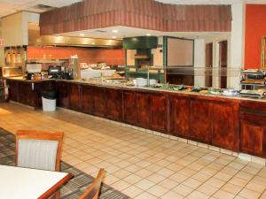 a large kitchen with a counter in a restaurant at Clarion Inn Fort Collins in Fort Collins