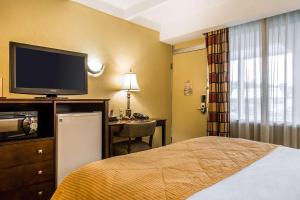 a bedroom with a bed and a television at Clarion Hotel & Suites Hamden - New Haven in Hamden
