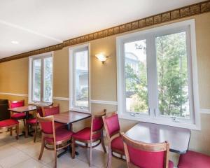 un comedor con mesas, sillas y ventanas en Econo Lodge Inn & Suites Old Saybrook - Westbrook, en Old Saybrook