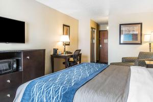 a hotel room with a bed and a flat screen tv at Comfort Inn & Suites in Meriden