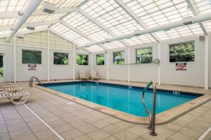 an indoor pool with a skylight and a swimming pool at Quality Inn & Suites Danbury near University in Danbury