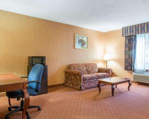 a hotel room with a couch and a table at Quality Inn & Suites Meriden in Meriden