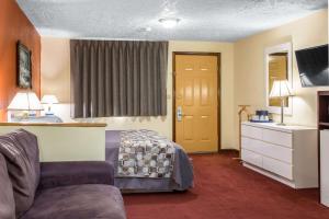 a hotel room with a bed and a couch at Rodeway Inn & Suites Branford - Guilford in Branford