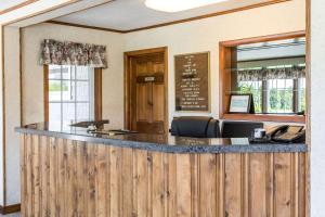 a bar in a restaurant with a wooden fence at Rodeway Inn Waterford - New London in Waterford