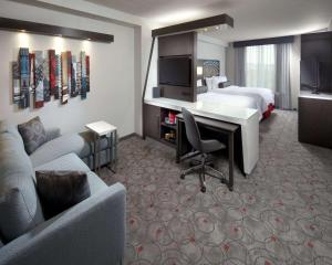 ワシントンにあるカンブリア ホテル ワシントン DC コンベンションセンターのベッド、デスク、ソファが備わるホテルルームです。