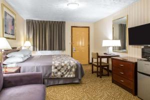 A bed or beds in a room at Rodeway Inn & Suites Branford - Guilford