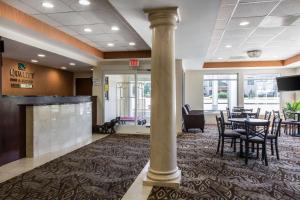 a lobby with a column and tables and chairs at Quality Inn & Suites Danbury near University in Danbury
