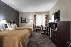 a hotel room with two beds and a flat screen tv at Quality Inn & Suites Danbury near University in Danbury