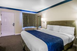 基西米Quality Inn Clermont West Kissimmee的一间卧室配有一张大床,提供蓝白色的毯子 更多21张照片