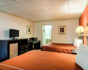 a hotel room with two beds and a flat screen tv at Rodeway Inn Newark in Newark