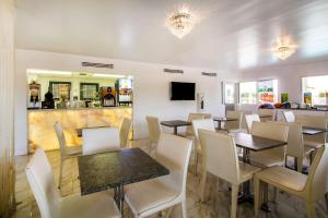 ein Restaurant mit Tischen und Stühlen und eine Bar in der Unterkunft Quality Inn Clermont West Kissimmee in Kissimmee
