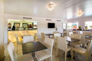 基西米Quality Inn Clermont West Kissimmee的有桌椅和酒吧的餐厅
